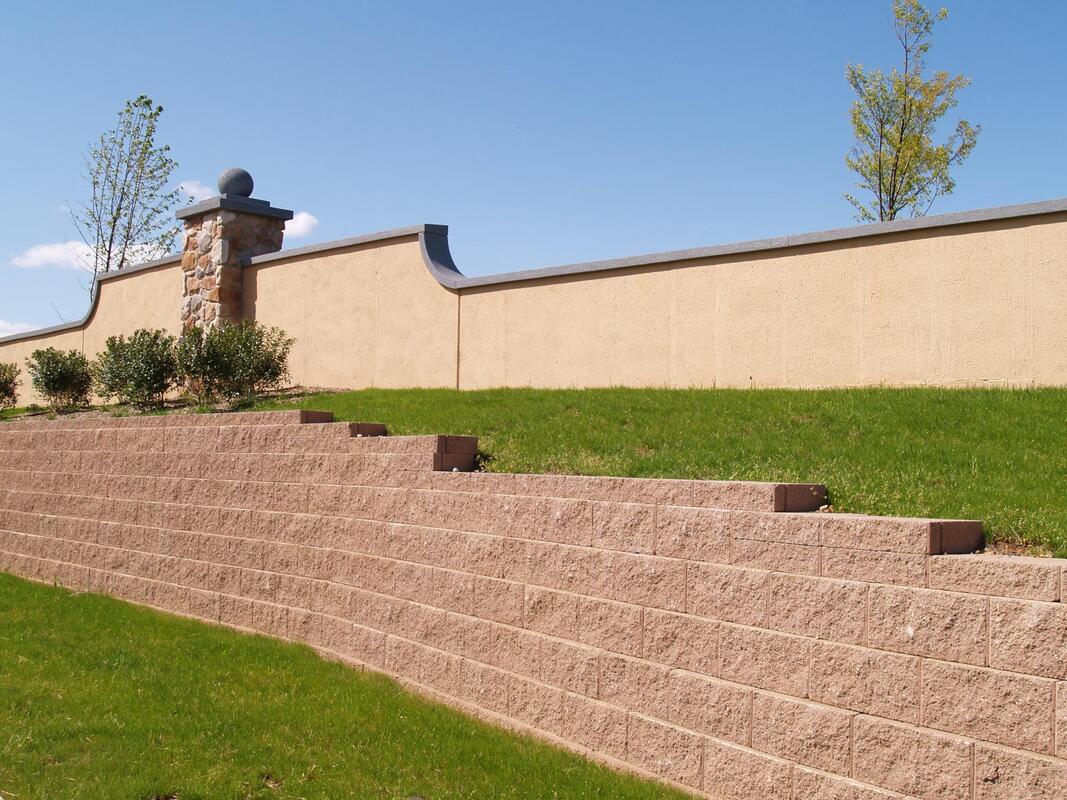Six foot high retaining wall next to grass for erosion control