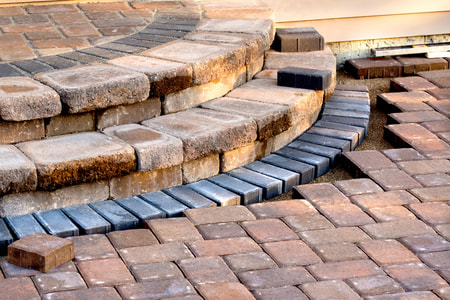 paved walk way leading to stone stairs, there are different colored bricks as accents near stairs